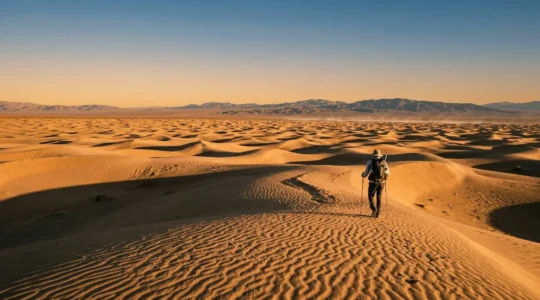 Randonneur dans le désert avec équipement d'hydratation et paysage aride