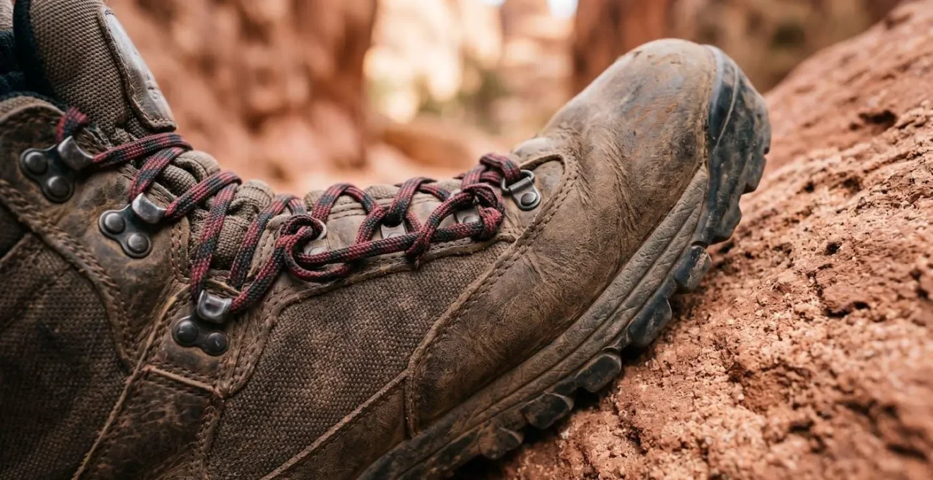 Gros plan sur des chaussures de randonnée avec technique de laçage spécifique sur rocher de grès rouge
